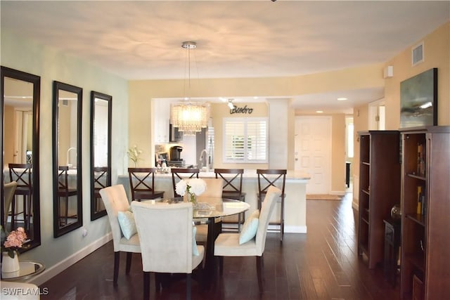 dining room with dark wood-style floors, baseboards, a notable chandelier, and visible vents