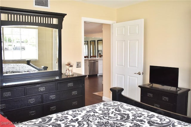 bedroom featuring wood finished floors, visible vents, and a sink