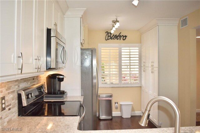 kitchen with white cabinets, decorative backsplash, visible vents, and appliances with stainless steel finishes