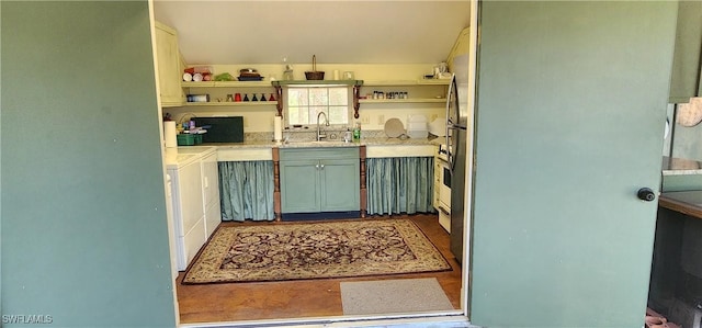 3105 Secretariat Dr, Labelle, FL 33935 - kitchen featuring separate washer and dryer, open shelves, light countertops, vaulted ceiling, and a sink