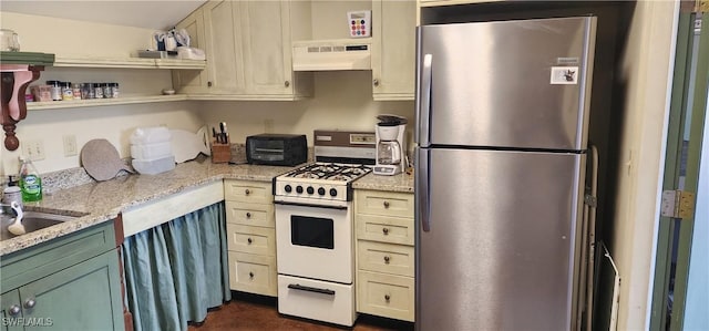 3105 Secretariat Dr, Labelle, FL 33935 - kitchen with light stone countertops, white range with gas cooktop, under cabinet range hood, and freestanding refrigerator