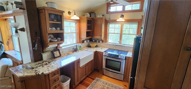 3105 Secretariat Dr, Labelle, FL 33935 - kitchen with glass insert cabinets, a sink, stainless steel electric stove, a ceiling fan, and brown cabinetry