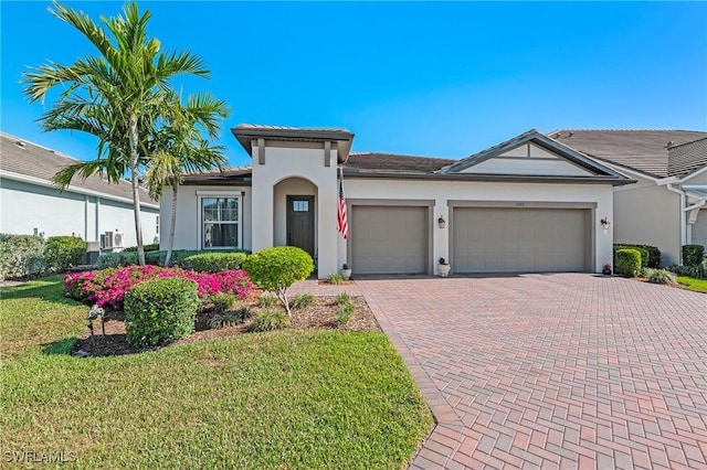3865 Helmsman Dr, Naples, FL 34120 - mediterranean / spanish home featuring a garage, stucco siding, decorative driveway, and a front yard