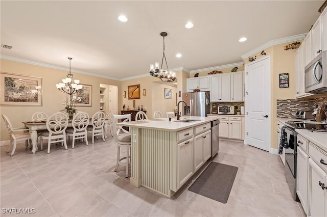 3865 Helmsman Dr, Naples, FL 34120 - kitchen featuring appliances with stainless steel finishes, a sink, a chandelier, decorative backsplash, and crown molding
