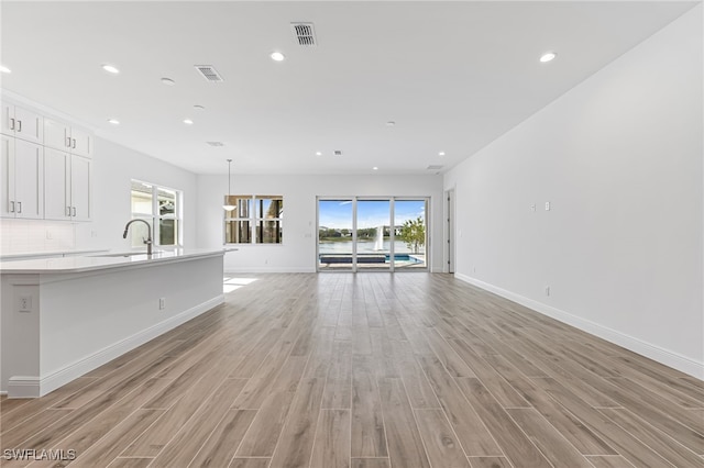 unfurnished living room featuring visible vents, light wood-type flooring, and recessed lighting