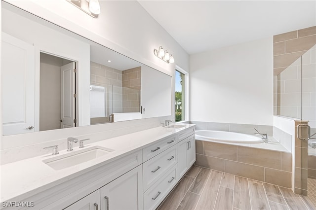 full bathroom with a stall shower, a bath, and a sink