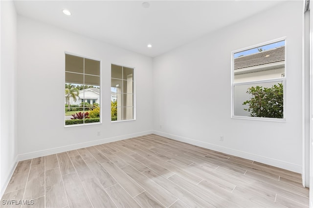 spare room with recessed lighting, baseboards, and light wood-style floors