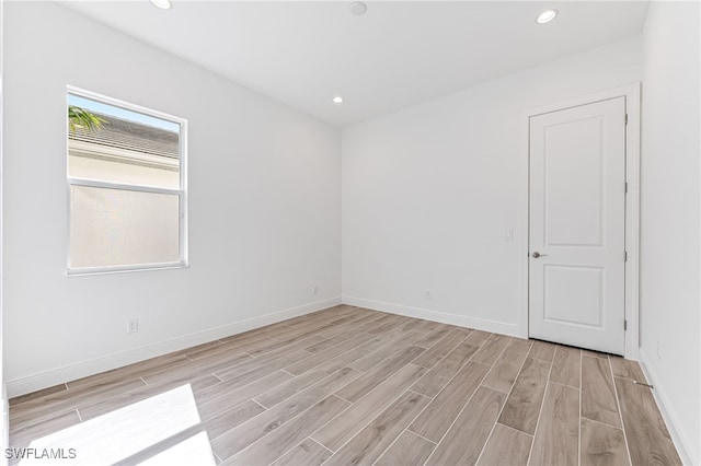 spare room with recessed lighting, light wood-style flooring, and baseboards