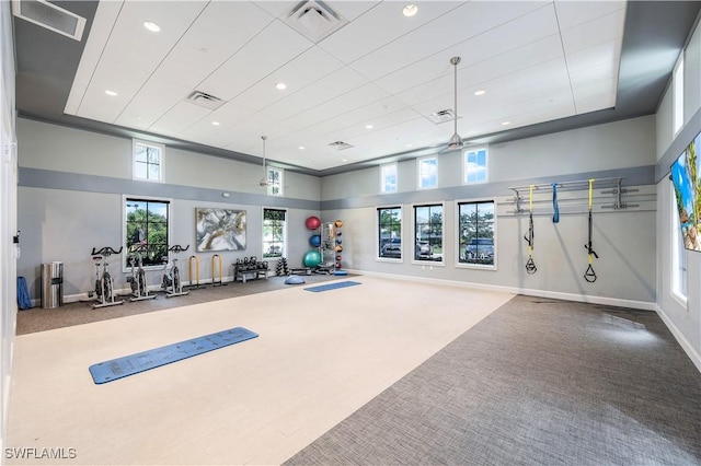 exercise room featuring recessed lighting, a towering ceiling, carpet, and plenty of natural light