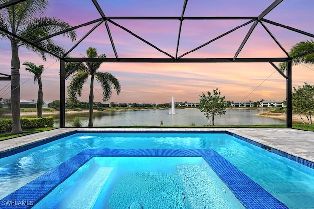 view of swimming pool with a lanai, a water view, and a pool with connected hot tub