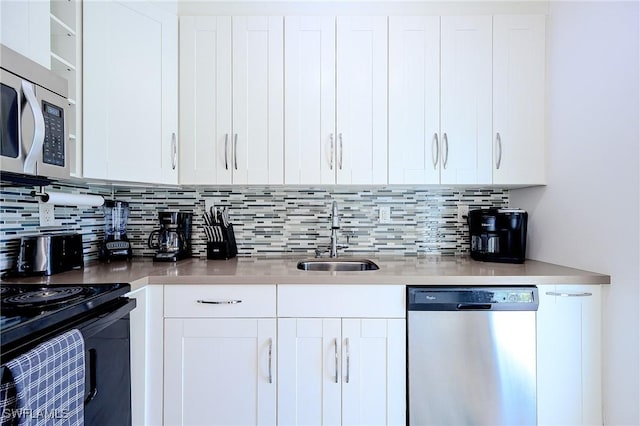 240 N Collier Blvd Unit G1, Marco Island, FL 34145 - kitchen with stainless steel appliances, a sink, white cabinetry, and decorative backsplash