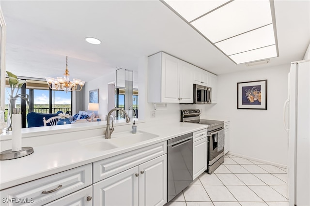 kitchen with a sink, white cabinets, baseboards, light countertops, and appliances with stainless steel finishes