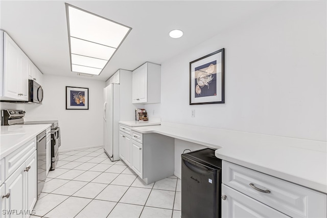 kitchen with light countertops, white cabinetry, stainless steel appliances, and light tile patterned floors