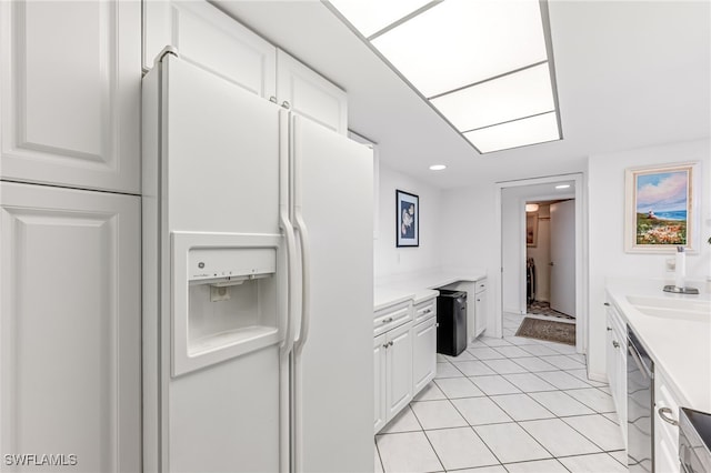kitchen with white fridge with ice dispenser, stainless steel dishwasher, a sink, white cabinetry, and light countertops