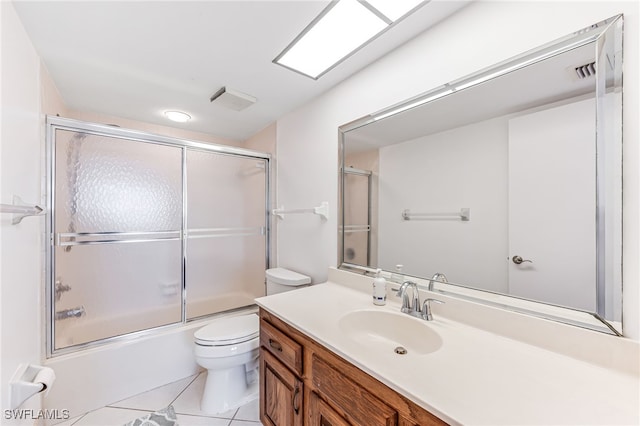 bathroom featuring toilet, visible vents, tile patterned flooring, bath / shower combo with glass door, and vanity