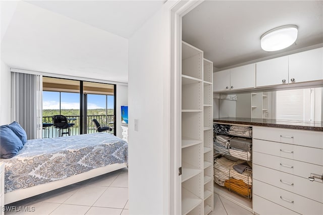 bedroom with light tile patterned floors and access to exterior