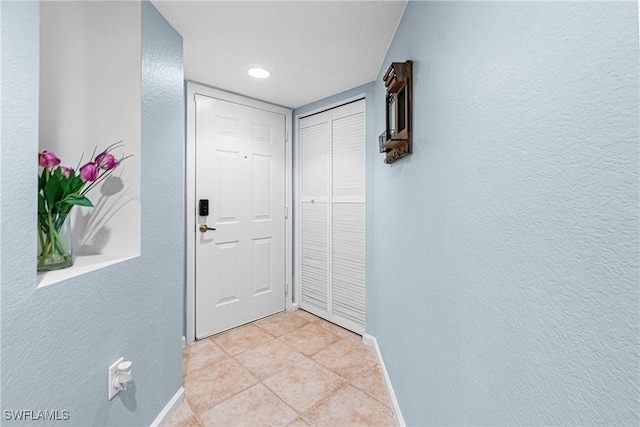 4121 Residence Dr Unit 303, Fort Myers, FL 33901 - doorway to outside with a textured wall, baseboards, and light tile patterned floors