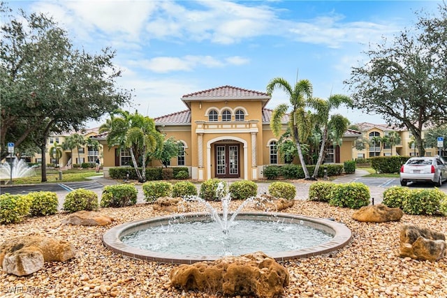 4121 Residence Dr Unit 303, Fort Myers, FL 33901 - view of front facade with a tiled roof, french doors, and stucco siding