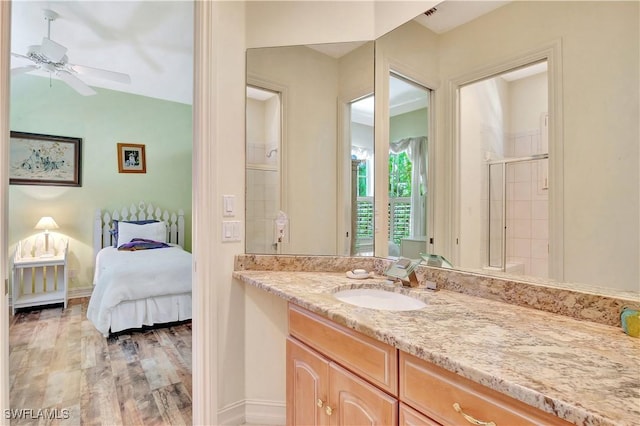 2363 Crayton Rd, Naples, FL 34103 - ensuite bathroom featuring vanity, wood finished floors, ceiling fan, a shower stall, and baseboards