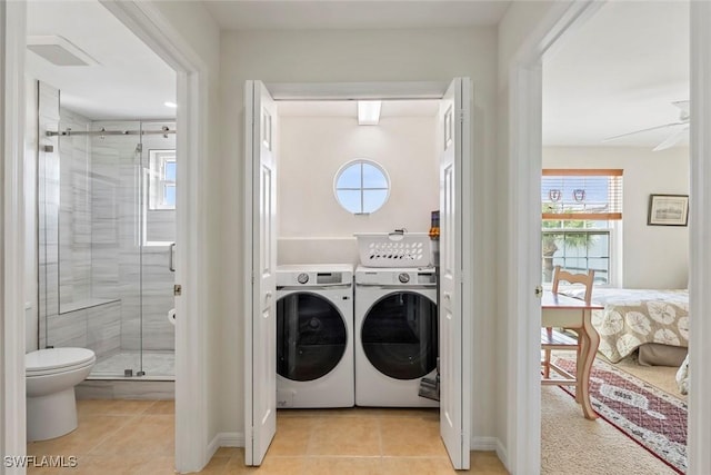washroom with independent washer and dryer, light tile patterned floors, and a healthy amount of sunlight