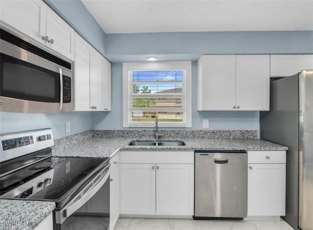 kitchen with marble finish floor, a sink, white cabinetry, and appliances with stainless steel finishes
