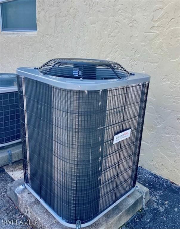exterior details with stucco siding and cooling unit
