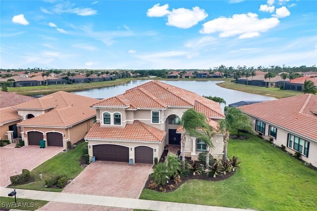 2927 Cinnamon Bay Cir, Naples, FL 34119 - view of front of home featuring a tile roof, decorative driveway, stucco siding, a water view, and a front yard