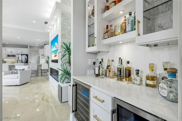 2927 Cinnamon Bay Cir, Naples, FL 34119 - indoor dry bar featuring wine cooler, stainless steel microwave, light marble finish flooring, and recessed lighting
