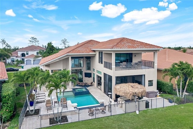 2927 Cinnamon Bay Cir, Naples, FL 34119 - rear view of property featuring a balcony, stucco siding, a patio area, a tile roof, and a pool with connected hot tub