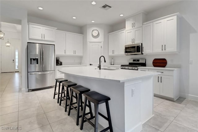 kitchen featuring a sink, a kitchen breakfast bar, light tile patterned floors, and stainless steel appliances