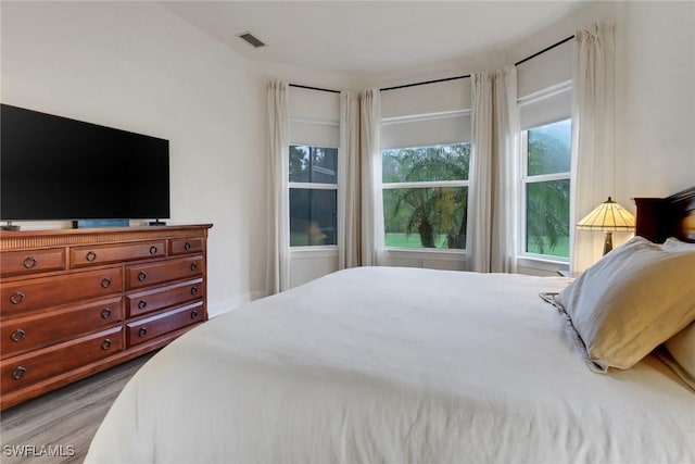 bedroom with light wood-style flooring and visible vents