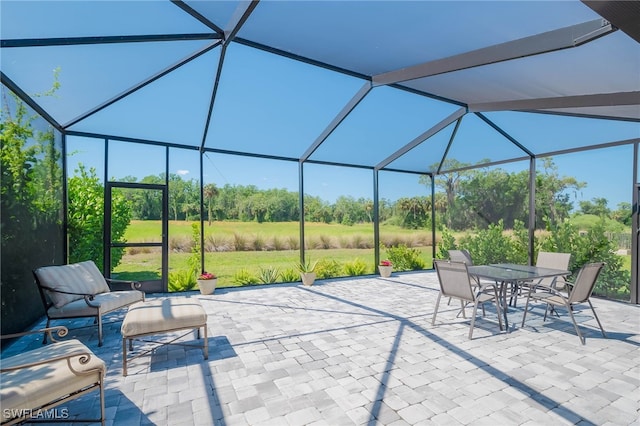 view of patio featuring outdoor dining space and glass enclosure