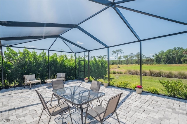 view of patio / terrace featuring outdoor dining space and glass enclosure