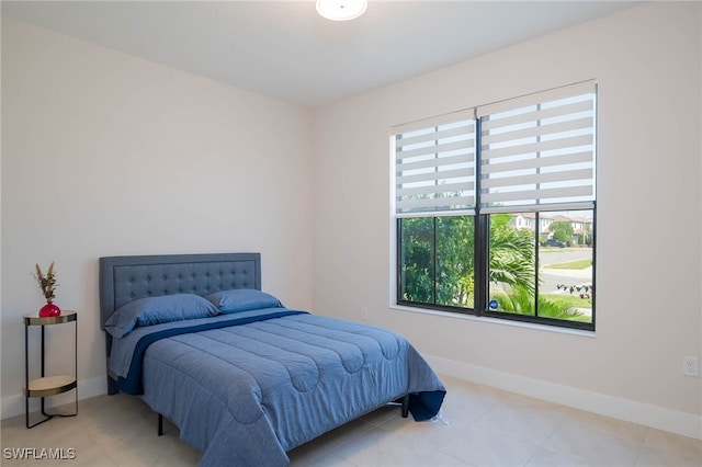 tiled bedroom featuring baseboards