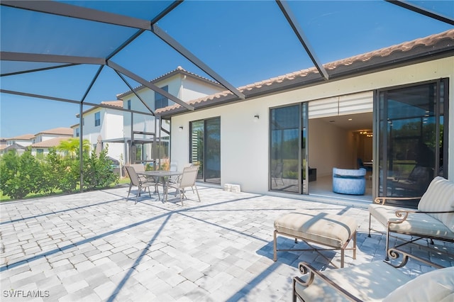 view of patio with glass enclosure and outdoor dining area