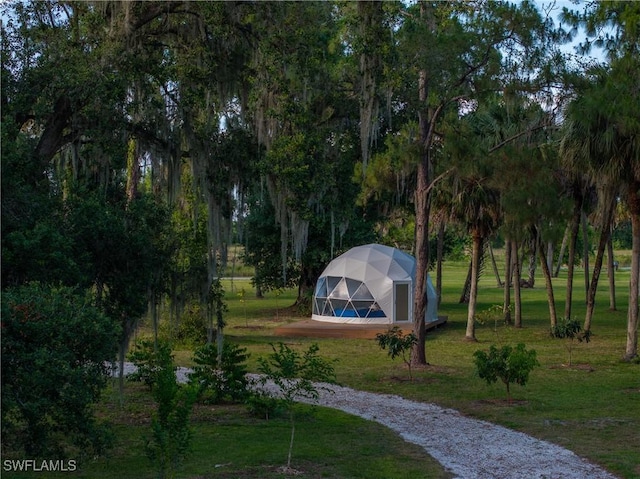 view of home's community with an exterior structure, gravel driveway, an outbuilding, and a yard