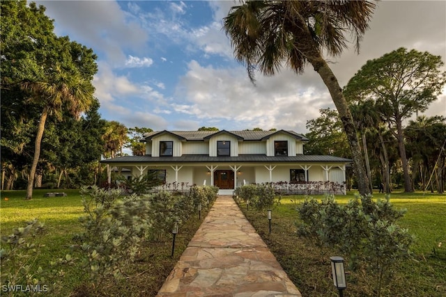 farmhouse featuring a porch and a front yard