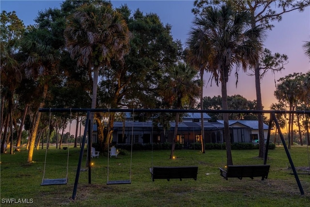 playground at dusk featuring a yard