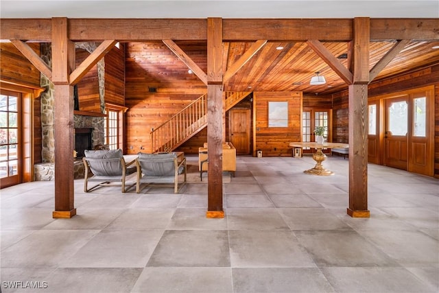 interior space with wood walls, a wealth of natural light, and stairway