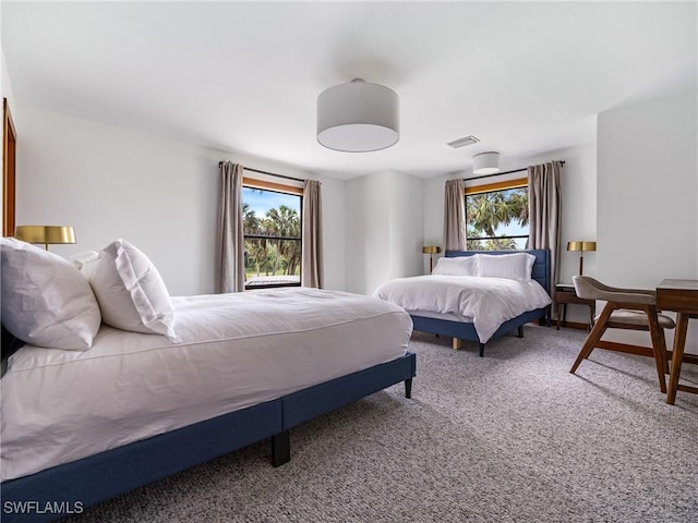 carpeted bedroom featuring visible vents and multiple windows