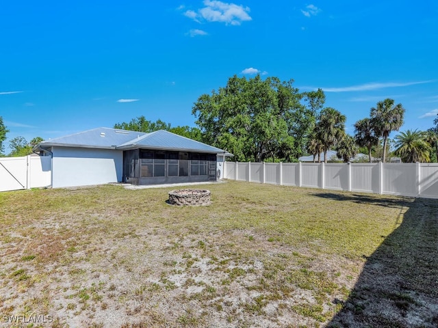 1210 Marlow St, Port Charlotte, FL 33952 - view of yard with a fenced backyard, an outdoor fire pit, and a sunroom