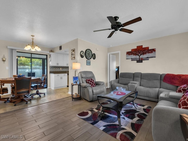 1210 Marlow St, Port Charlotte, FL 33952 - living room with light wood-style floors and ceiling fan with notable chandelier