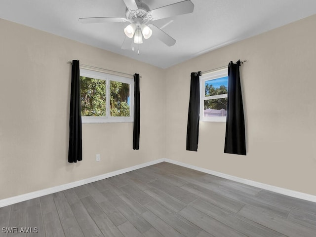 1210 Marlow St, Port Charlotte, FL 33952 - unfurnished room with a wealth of natural light, a ceiling fan, wood finished floors, and baseboards