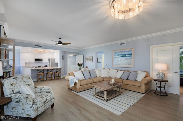 4761 W Bay Blvd Unit 303, Estero, FL 33928 - living room featuring light wood-style floors, ceiling fan, a chandelier, and ornamental molding