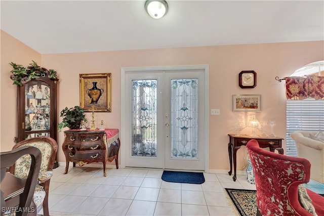 foyer featuring light tile patterned floors, baseboards, and french doors
