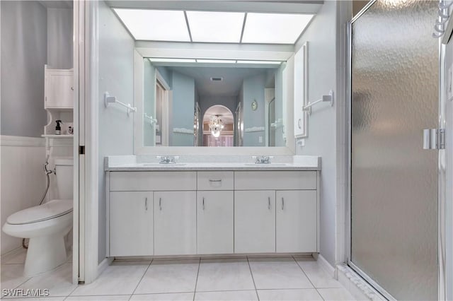 bathroom with a sink, tile patterned flooring, a stall shower, and toilet
