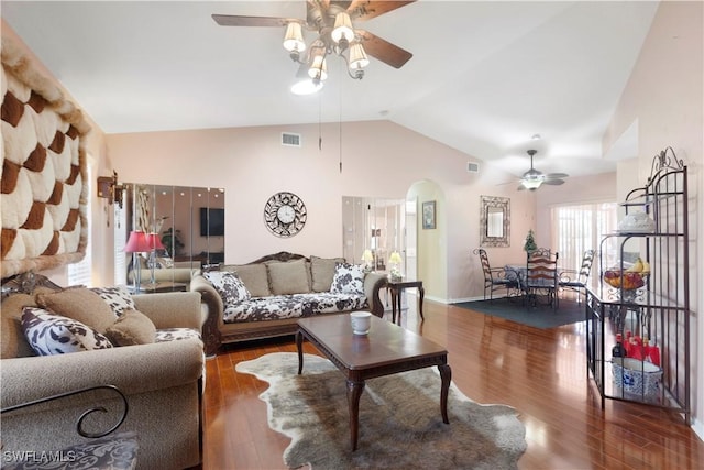 living area featuring arched walkways, a ceiling fan, baseboards, wood finished floors, and visible vents