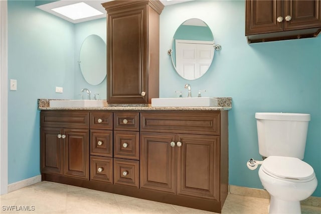 212 SE 30th Ter, Cape Coral, FL 33904 - bathroom with toilet, baseboards, double vanity, and tile patterned floors