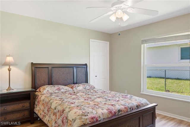 212 SE 30th Ter, Cape Coral, FL 33904 - bedroom with light wood finished floors, a closet, a ceiling fan, and baseboards