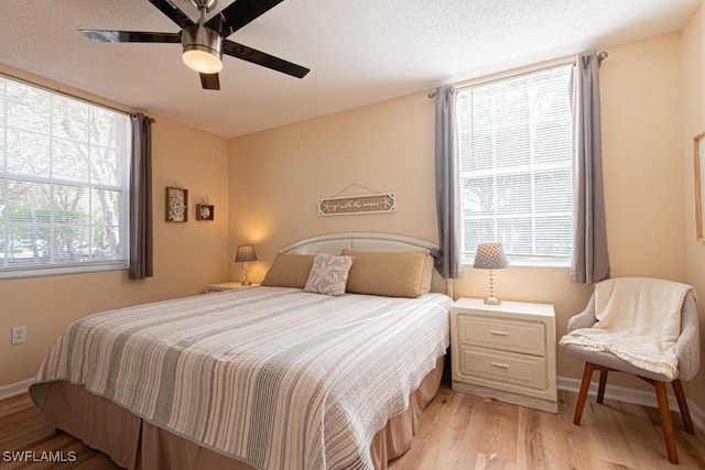 8617 River Homes Ln Unit 3108, Bonita Springs, FL 34135 - bedroom with light wood-type flooring, baseboards, a ceiling fan, and a textured ceiling